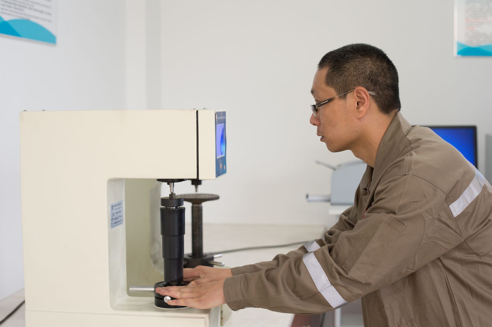 Técnico operando durômetro de bancada para medir a dureza de uma amostra